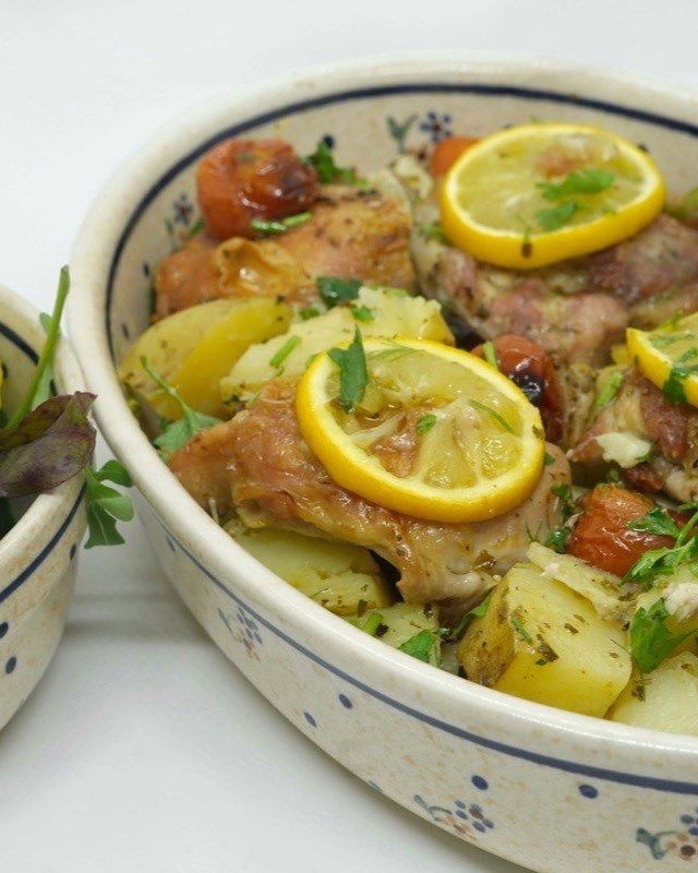Greek Sheet Pan Lemon Chicken and Potatoes — plated, with the roasted lemon squeezed over